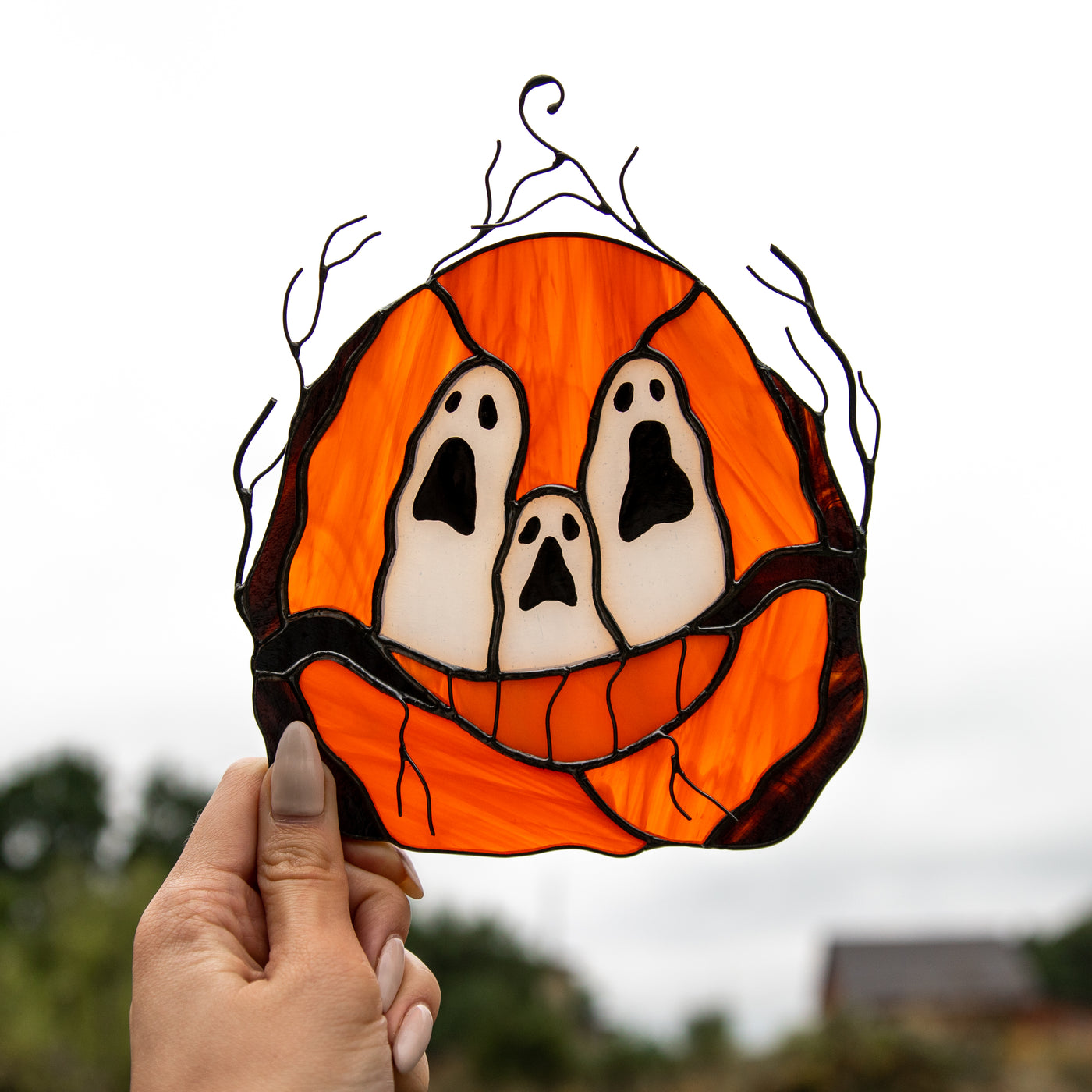 Stained glass suncatcher of spooky ghost-eyes pumpkin