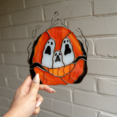 Stained glass ghost-eyed pumpkin window hanging for ghastly decor on Halloween