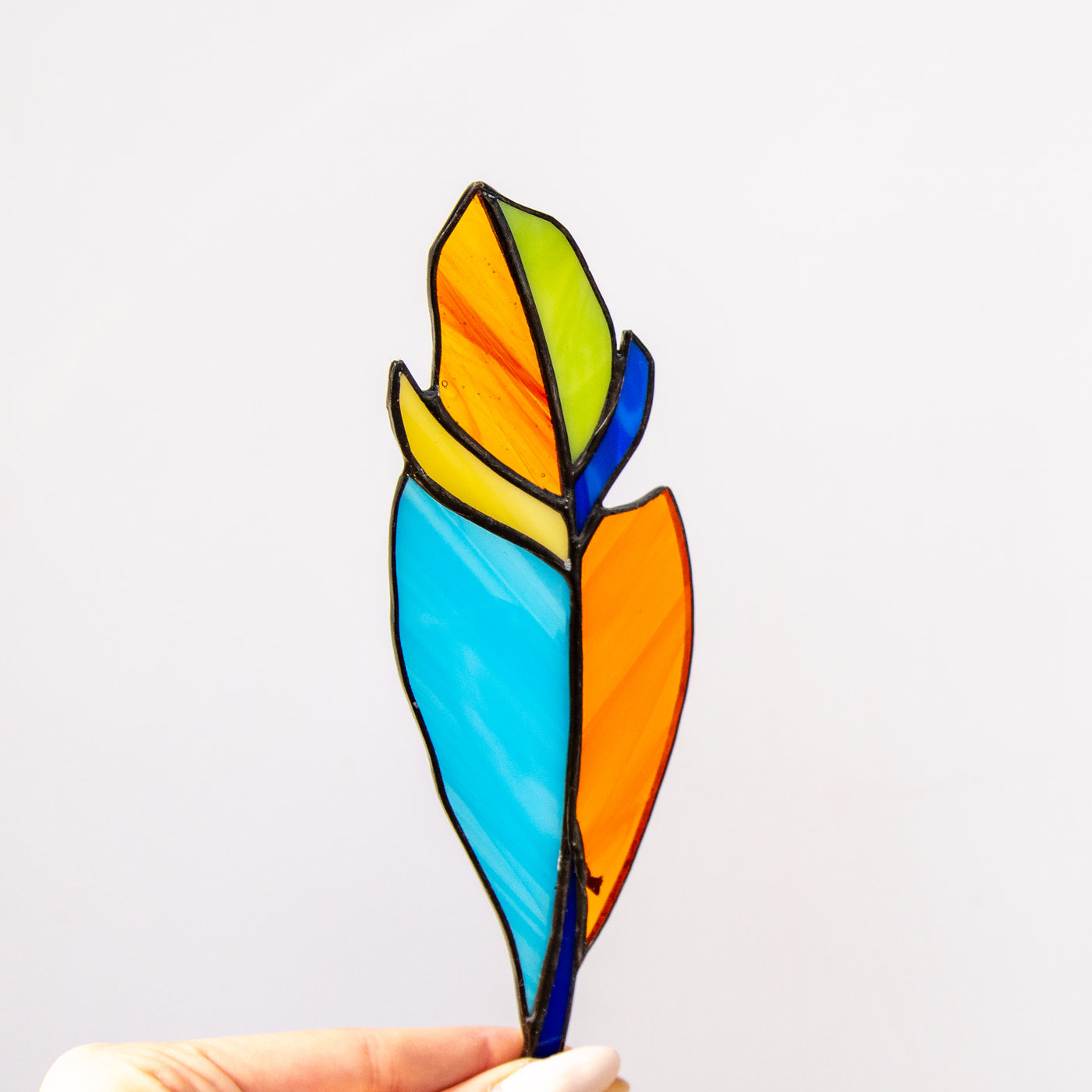 Bright colourful feather suncatcher of stained glass for window 