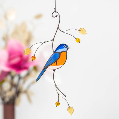 Stained glass bluebird suncatcher hanging on the tree