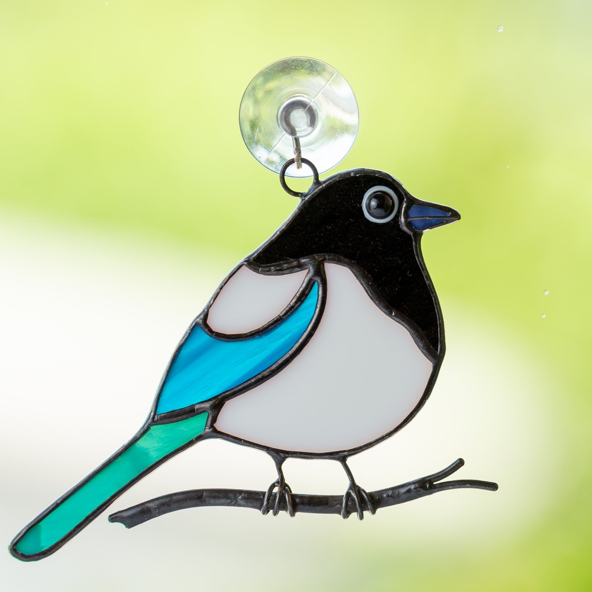 small fat magpie sitting on a branch stained glass suncatcher