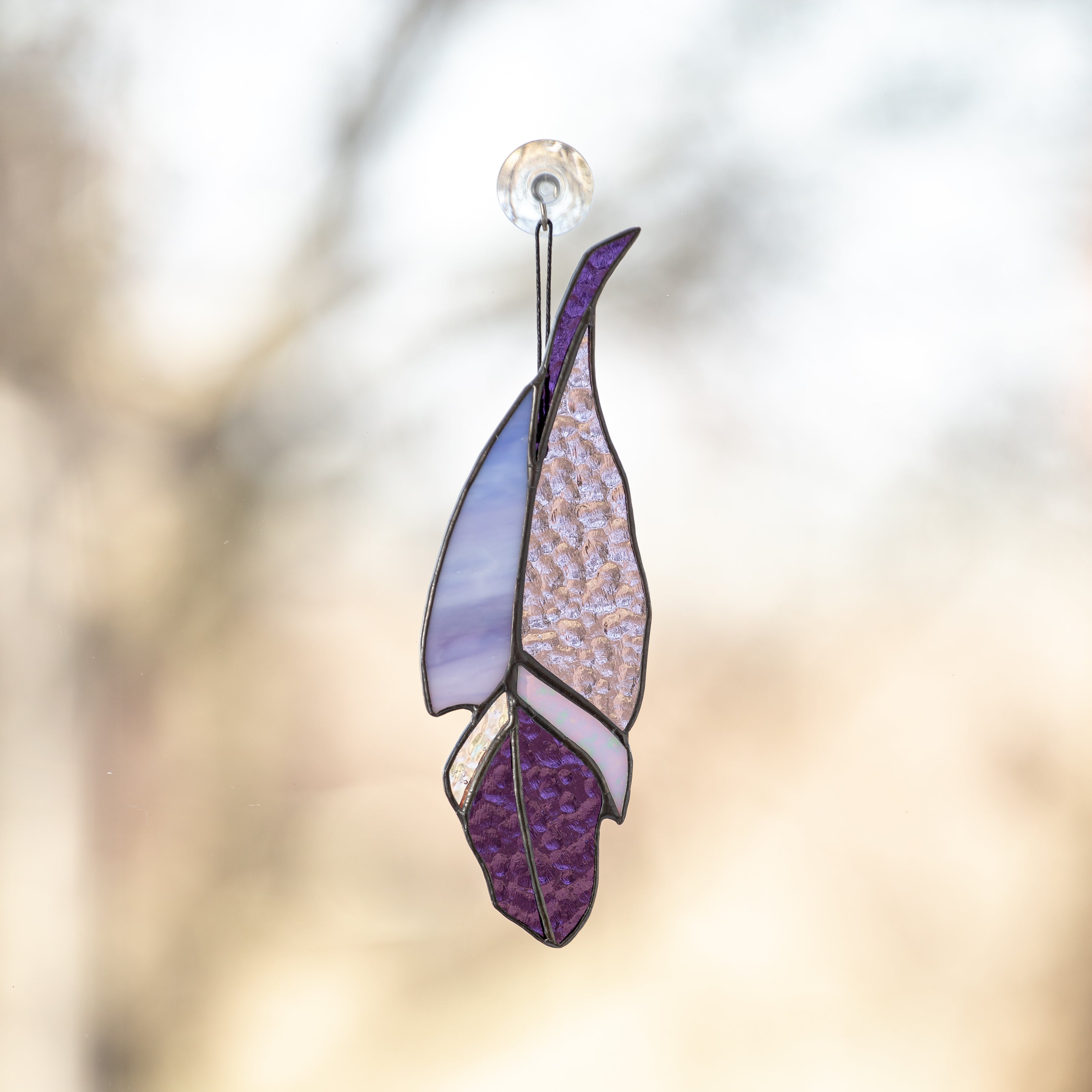 Stained glass feather suncatcher of purple colour