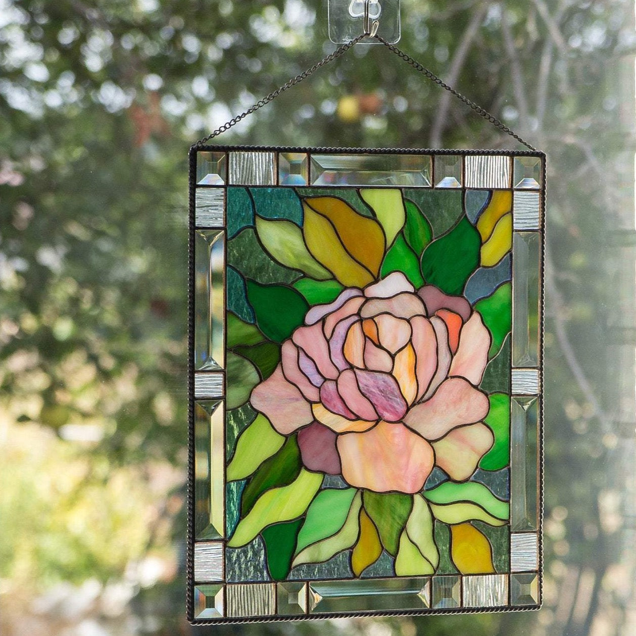 Stained glass window hanging depicting pink peony with leaves 