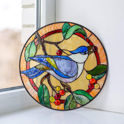 Stained glass round panel depicting blue jay bird with berries 