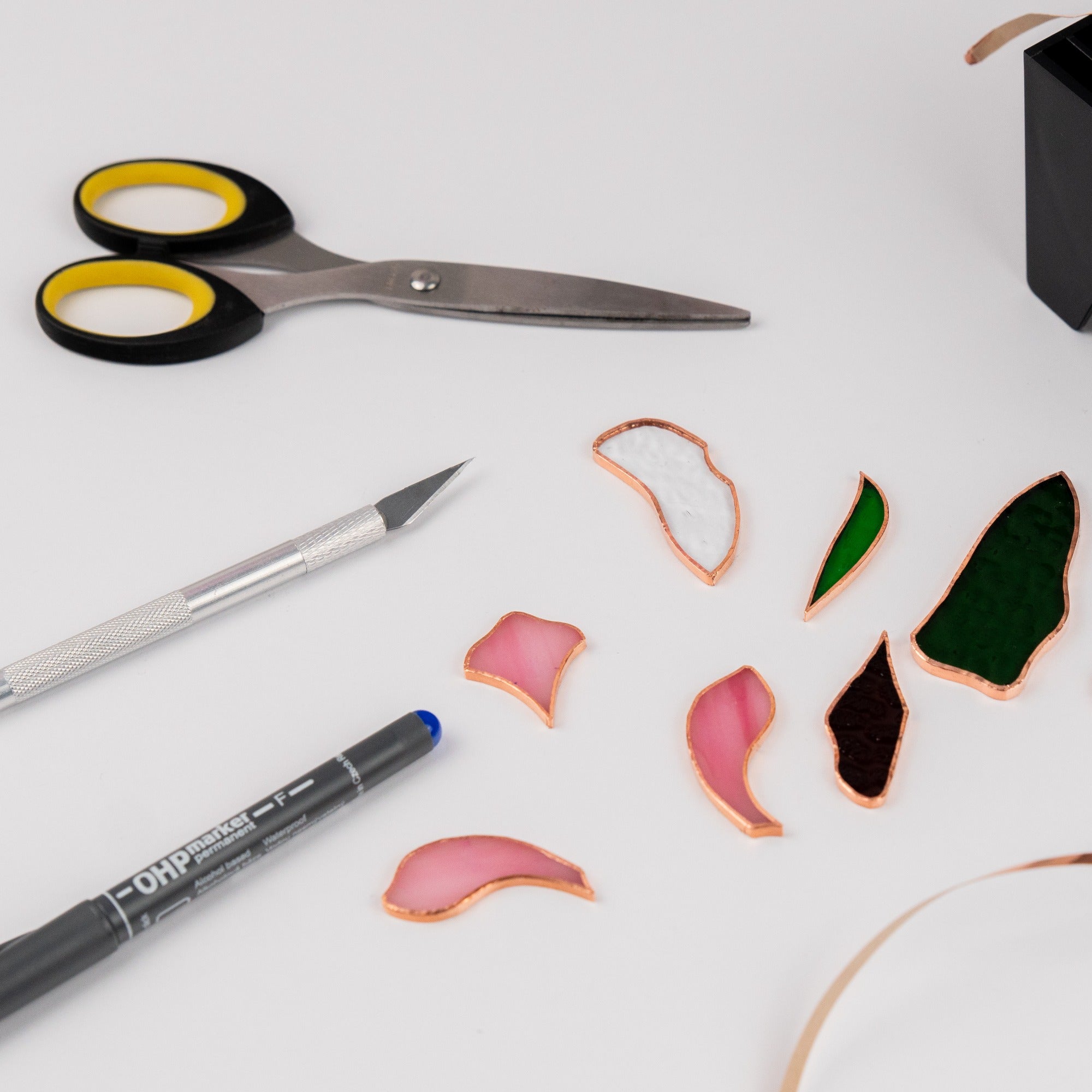 Craftsman cutting stained glass pieces using professional tools