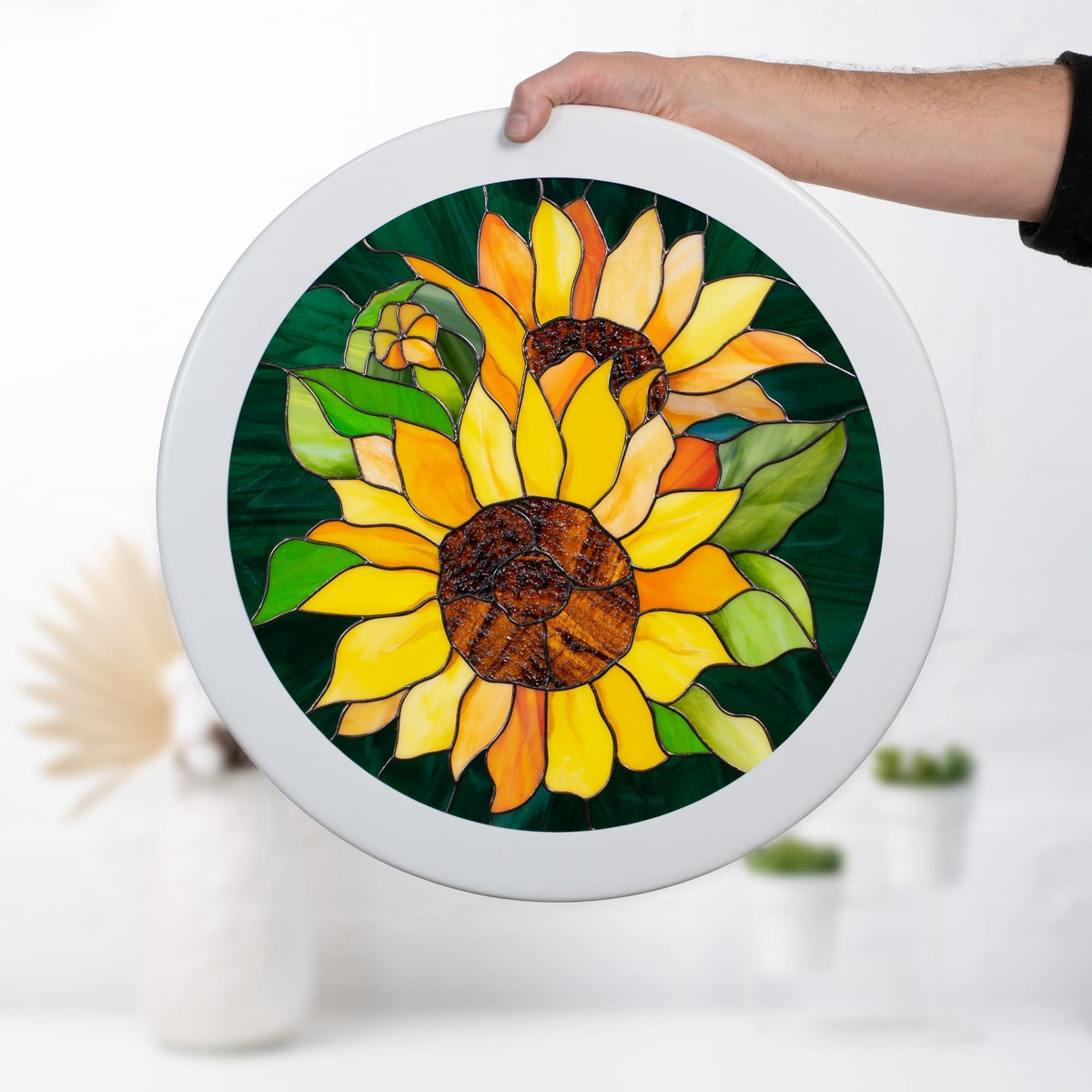 Round stained glass sunflower window panel in a white frame