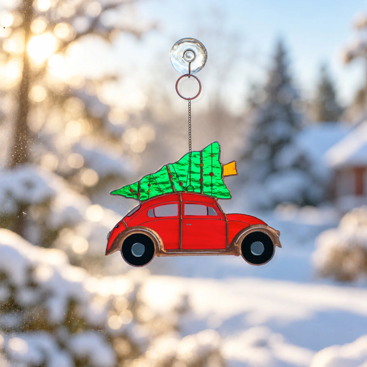 Stained glass red car with Christmas tree suncatcher handing on the window