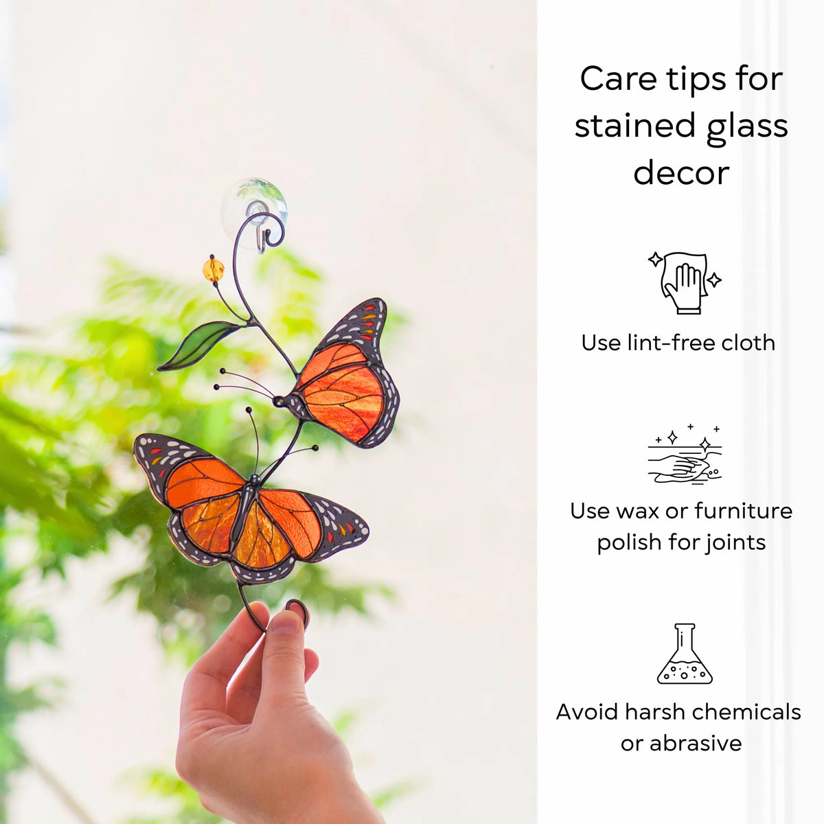 Care tips for stained glass decor beside a monarch butterfly suncatcher held at a sunlit window - use a lint-free cloth, wax the joints, avoid harsh chemicals and abrasives
