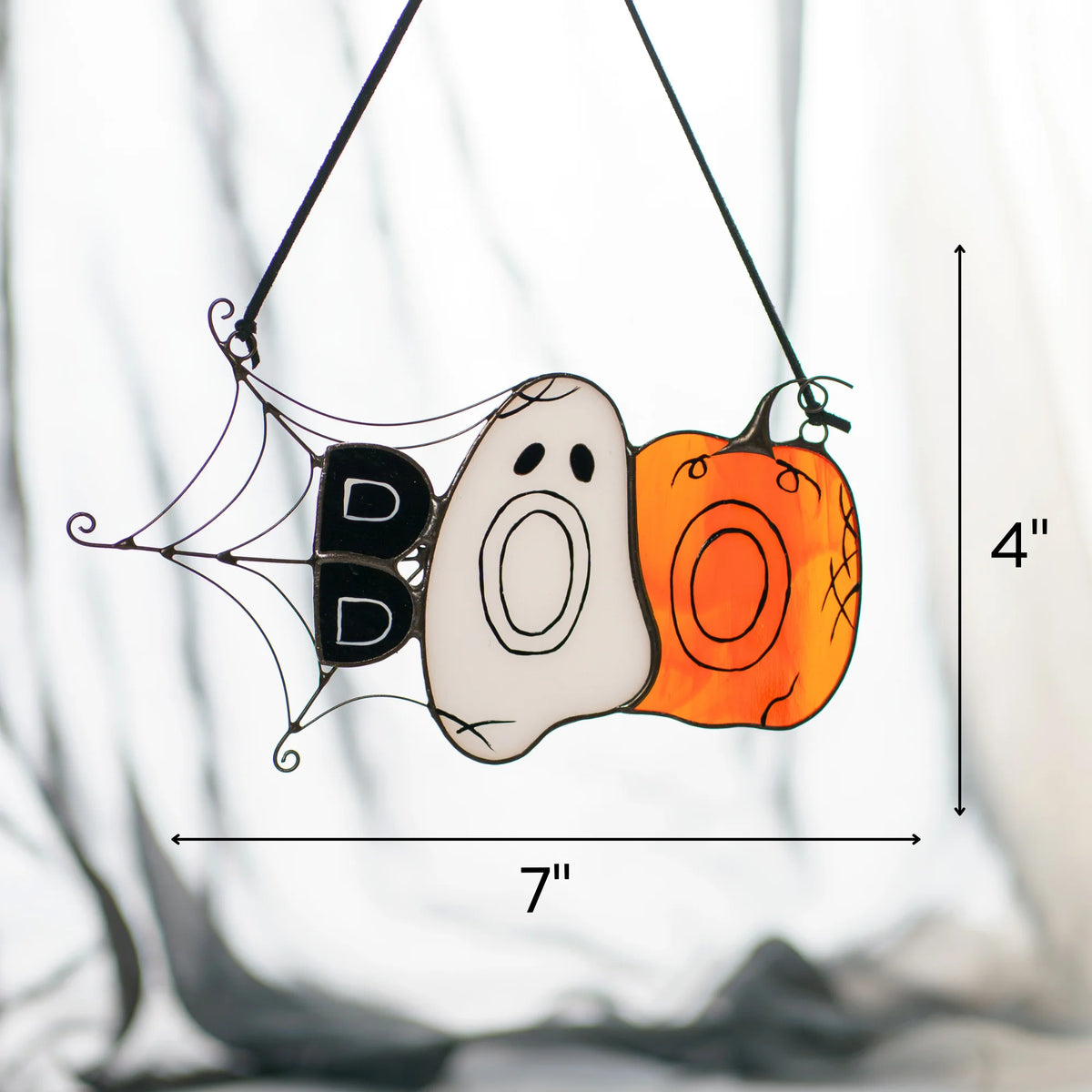Size guide for the handmade BOO Halloween stained glass suncatcher - 7 inches wide and 4 inches tall, a small ghost and pumpkin window hanging on a black cord