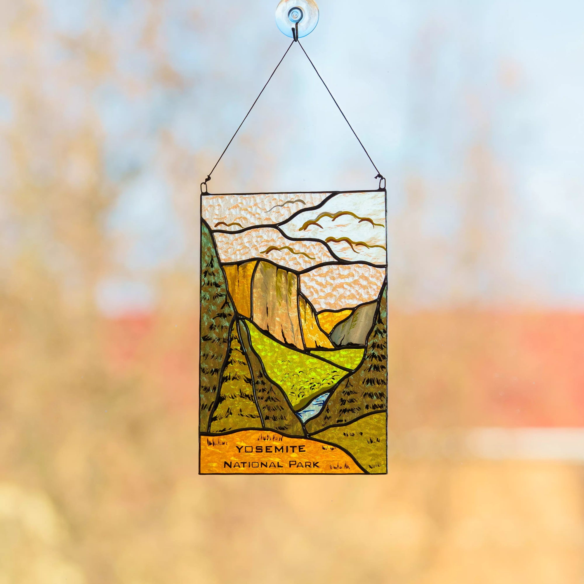 Stained glass panel of Yosemite National Park with a blurred natural background