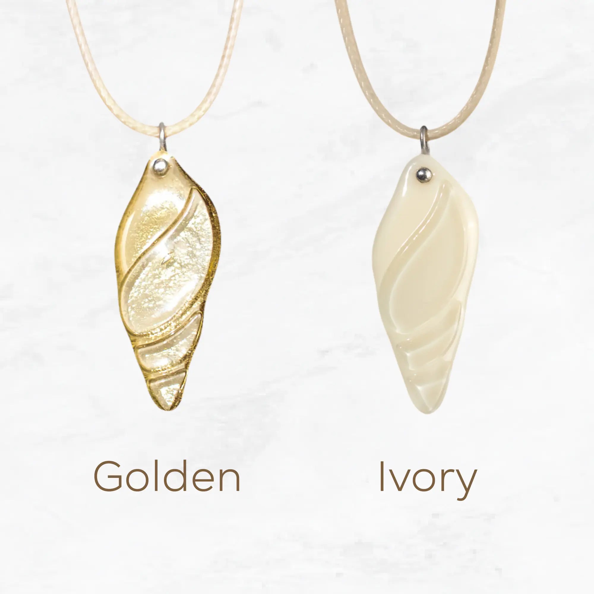 Variation of Two stained glass necklaces, one gold and one ivory, on a light background.