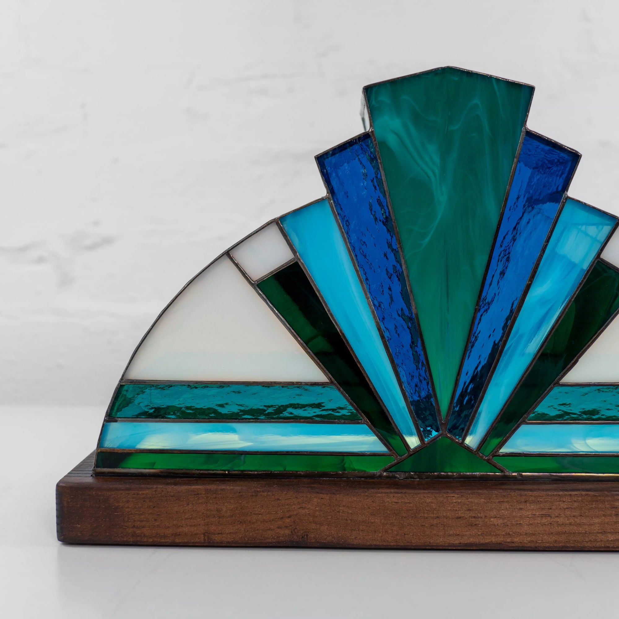 Aqua and navy stained glass lamp detail view with reflections and sturdy wooden stand, artistic handmade lighting piece.