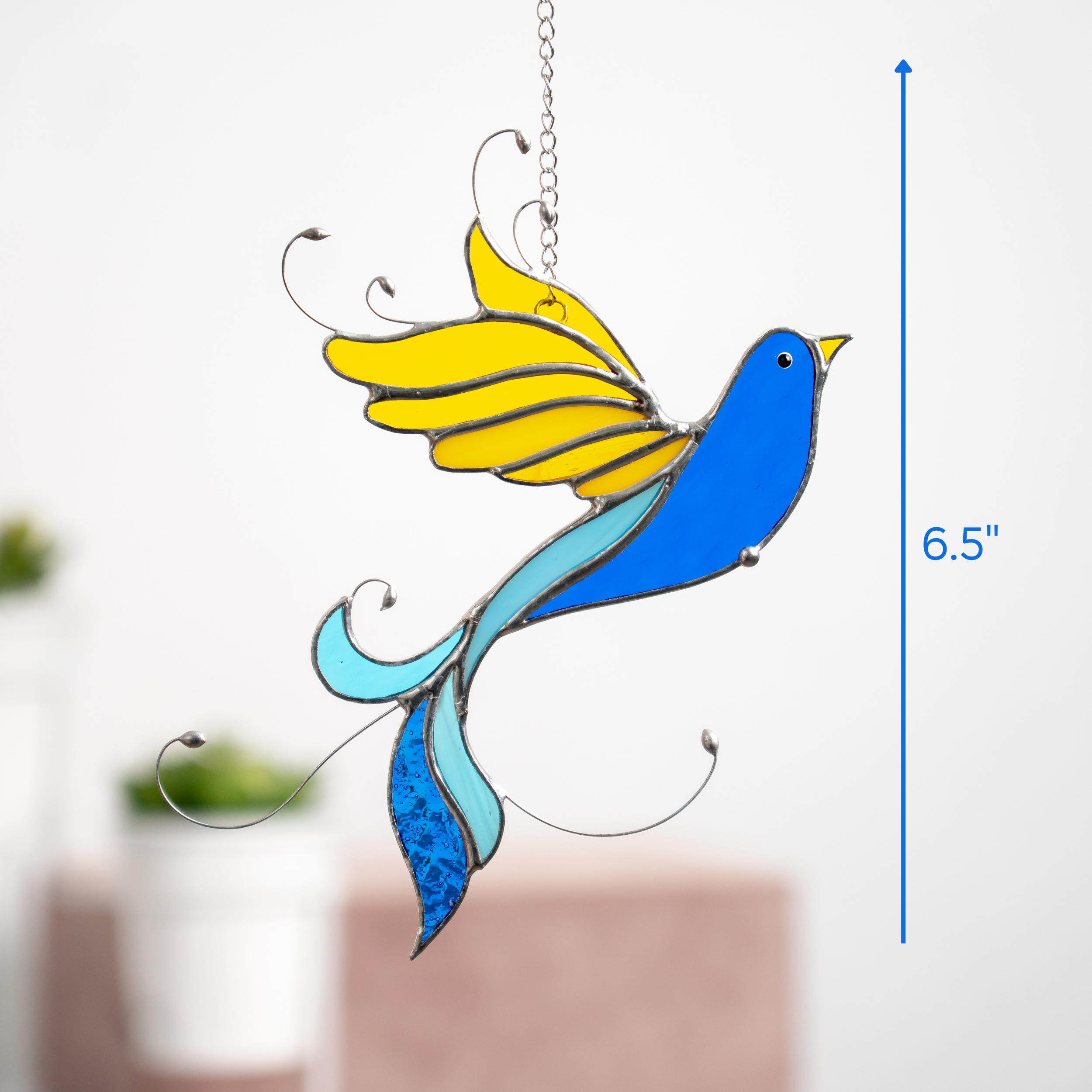 Stained glass bird shown hanging on white background with vertical scale showing 6.5" size.