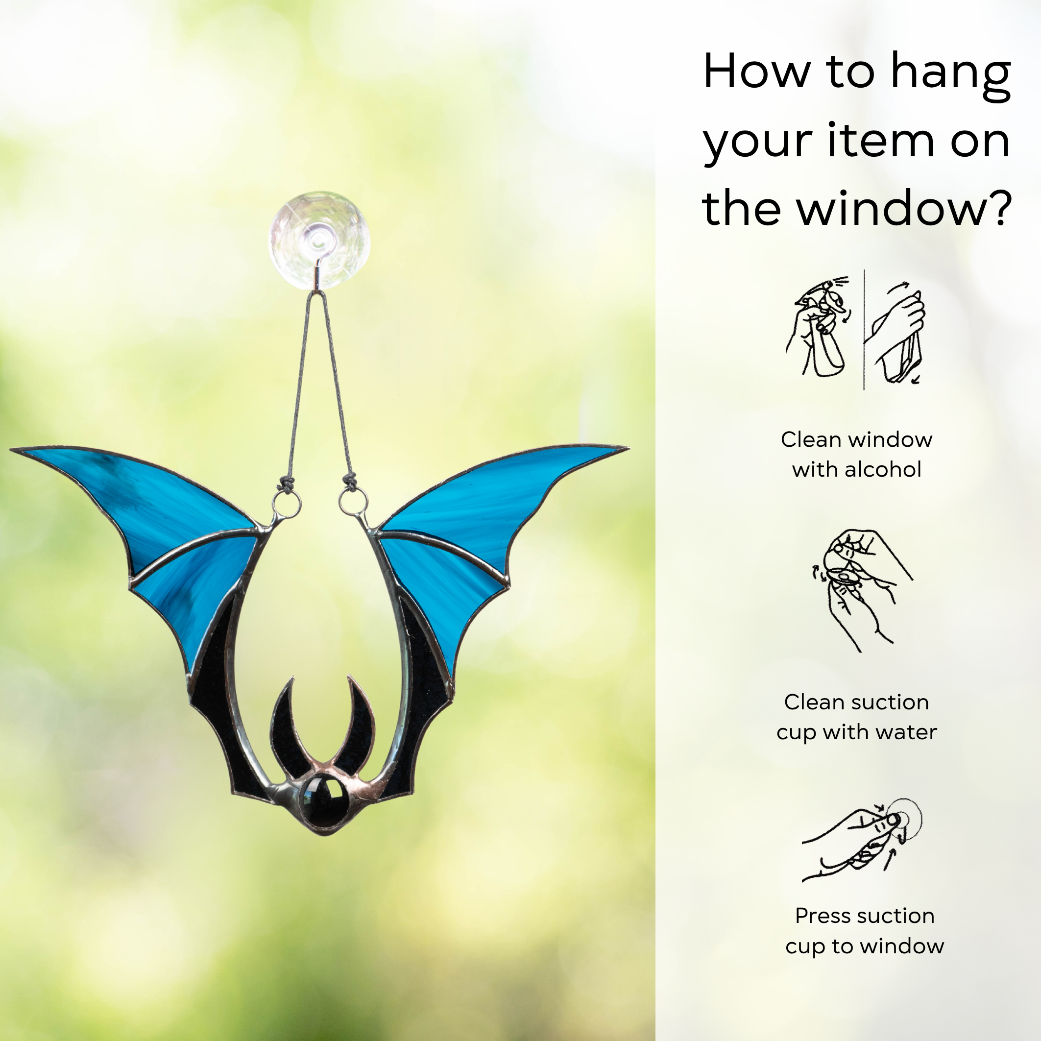 Bat-shaped stained glass suncatcher with blue wings hanging on window with suction cup and instruction beside: clean window and suction cup, press a cup to the surface.