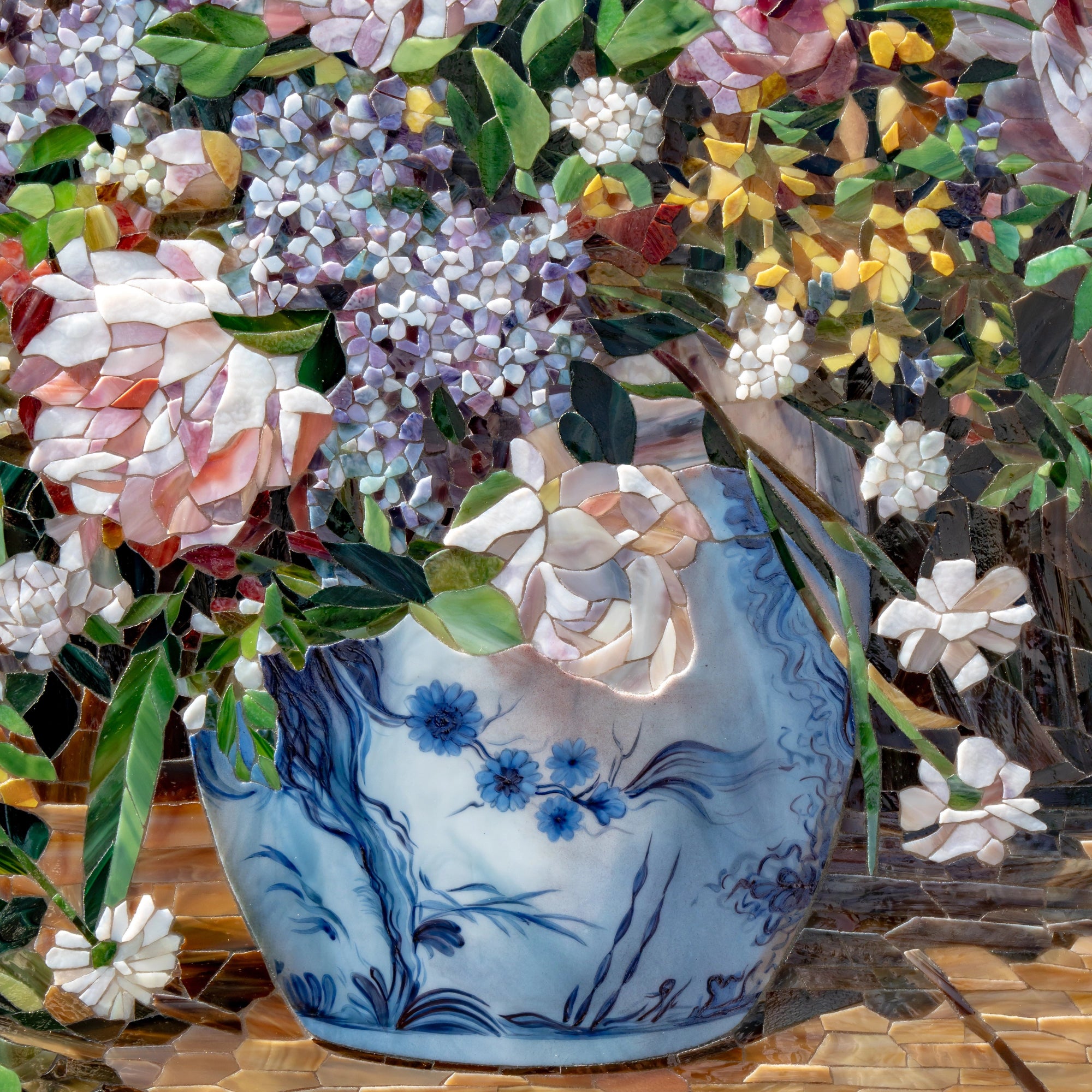 Detailed view of a blue ceramic vase in a stained glass mosaic, decorated with delicate floral motifs and filled with spring flowers inspired by Renoir still life paintings.