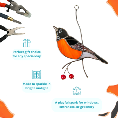 Colorful stained glass American robin with metal branches, surrounded by craft tools.