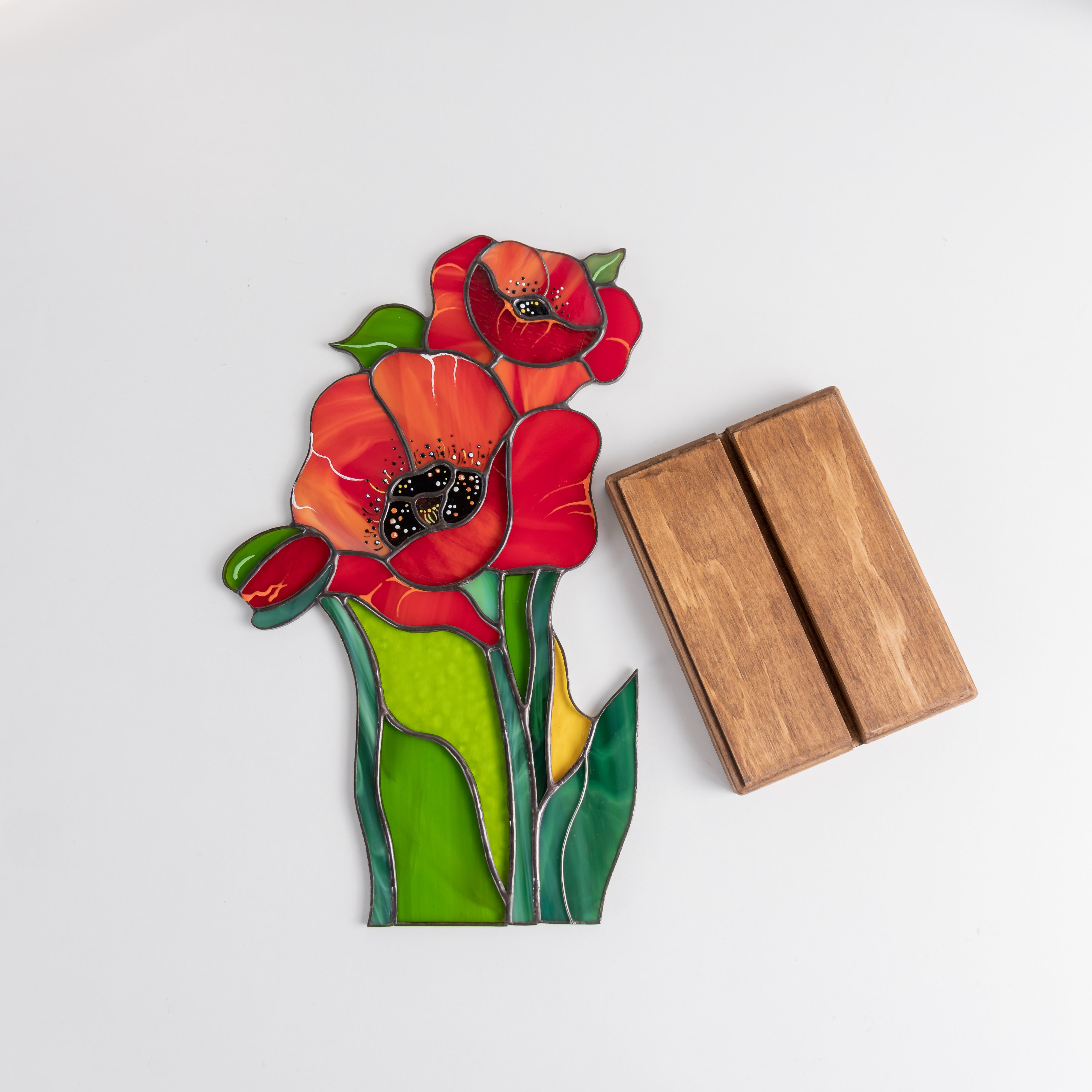 Stained glass poppy flowers and a separate wooden base displayed on a white background, ready for assembly.
