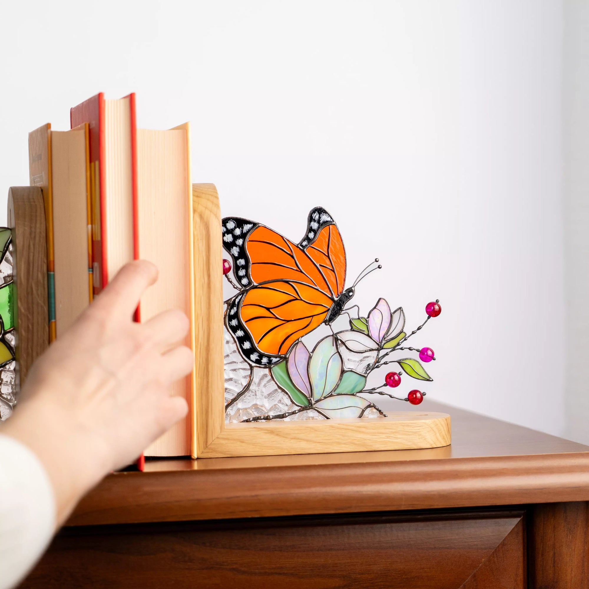 Stained glass butterfly bookend showing detailed wings, glass flowers, and textured clear glass background.