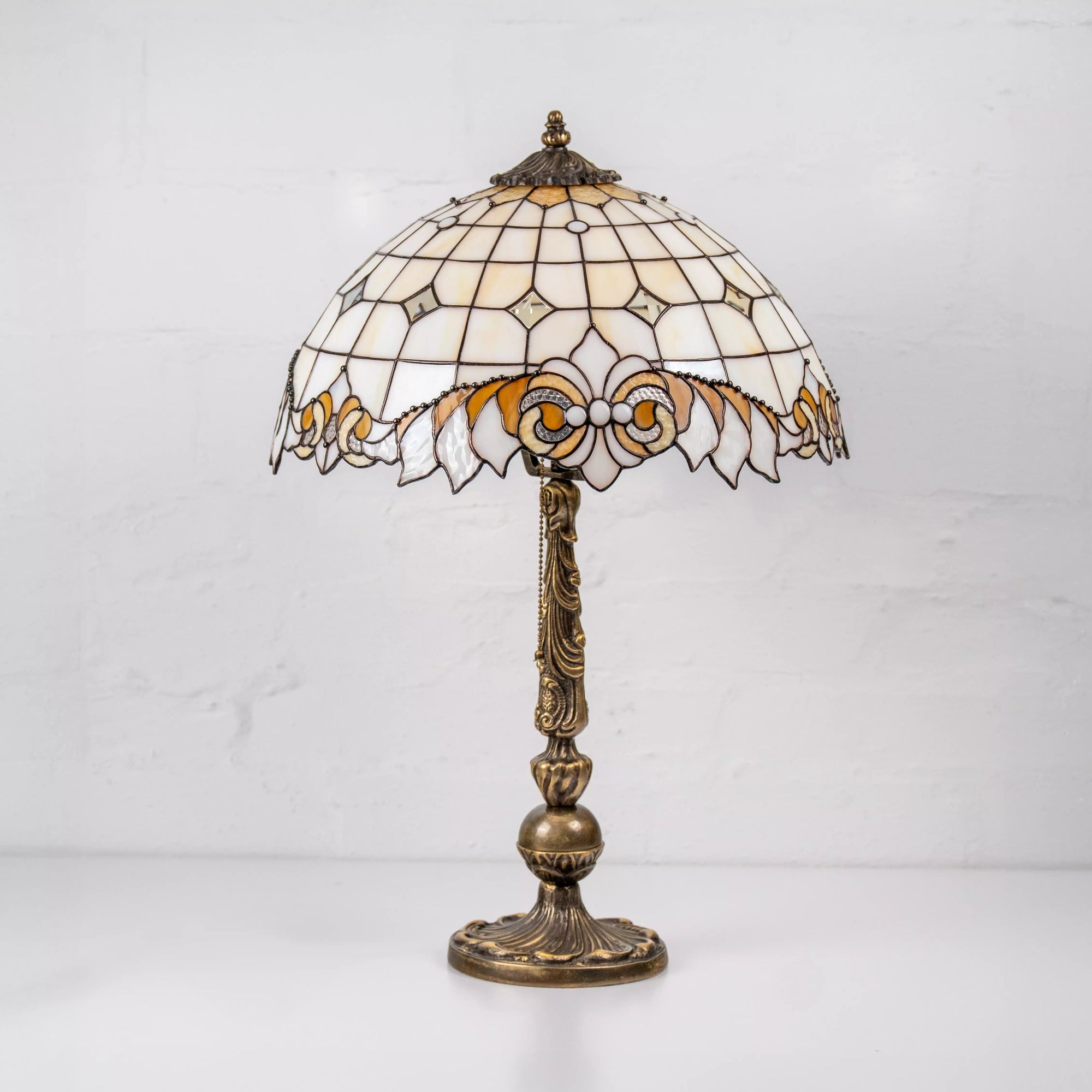 Side view of stained glass table lamp with detailed base and floral patterned shade