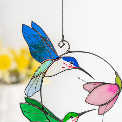 Close-up view of the blue hummingbird and pink flower made from stained glass