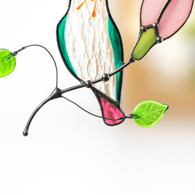 Close view of tail and leaves on hummingbird stained glass suncatcher showing craftsmanship and detail.