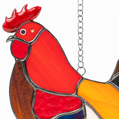 Detailed view of the stained glass rooster's head with red crown and fine craftsmanship.