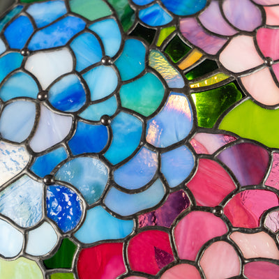 Vivid stained glass mosaic in blue and pink flower petals with rich texture and shine.
