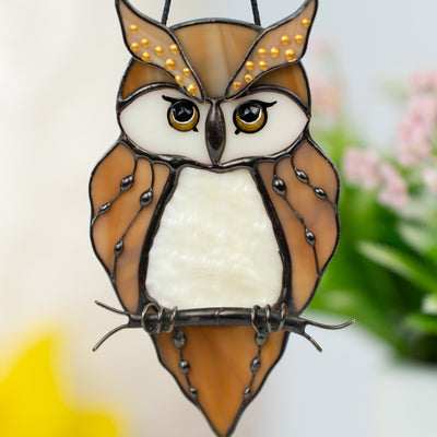 Macro photo of owl’s yellow glass eyes and decorated wings