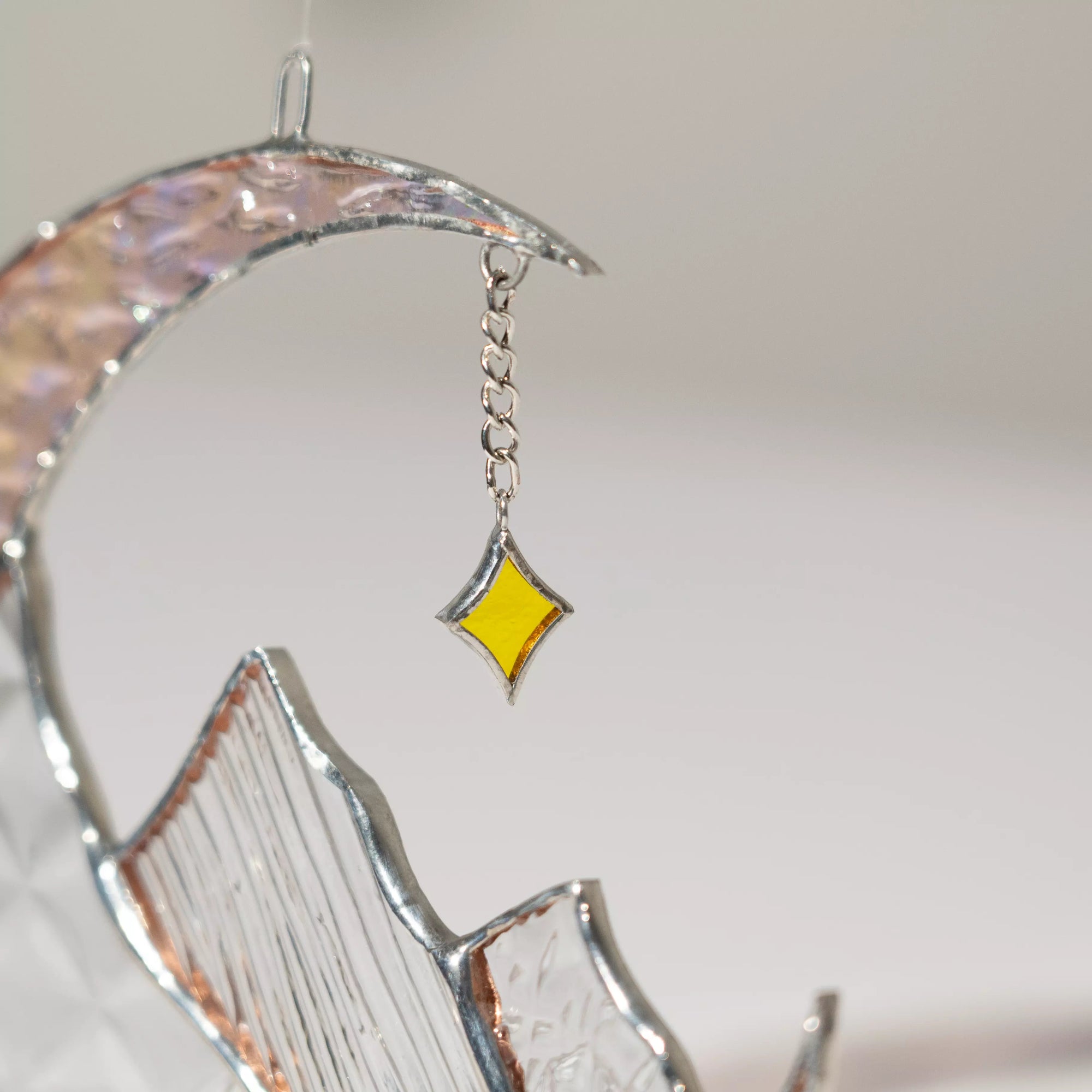 Close-up view of stained glass star detail on a celestial moon suncatcher