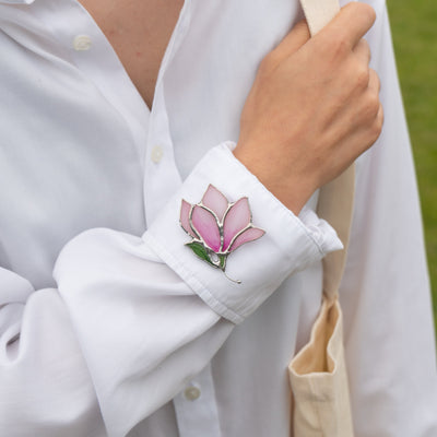 Magnolia flower pin of stained glass on a white shirt