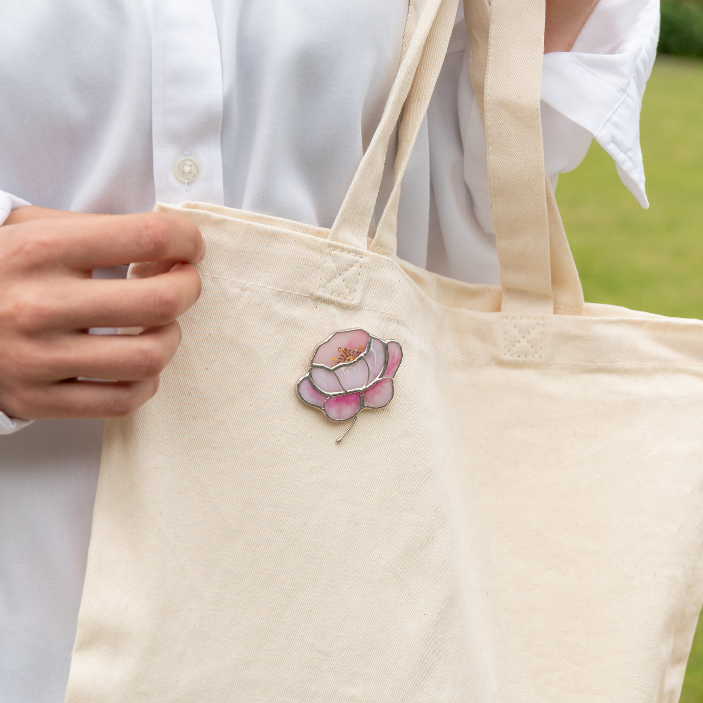 Peony brooch of stained glass on a shopping bag
