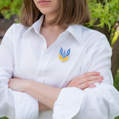 Stained glass Ukrainian trident brooch on a white shirt