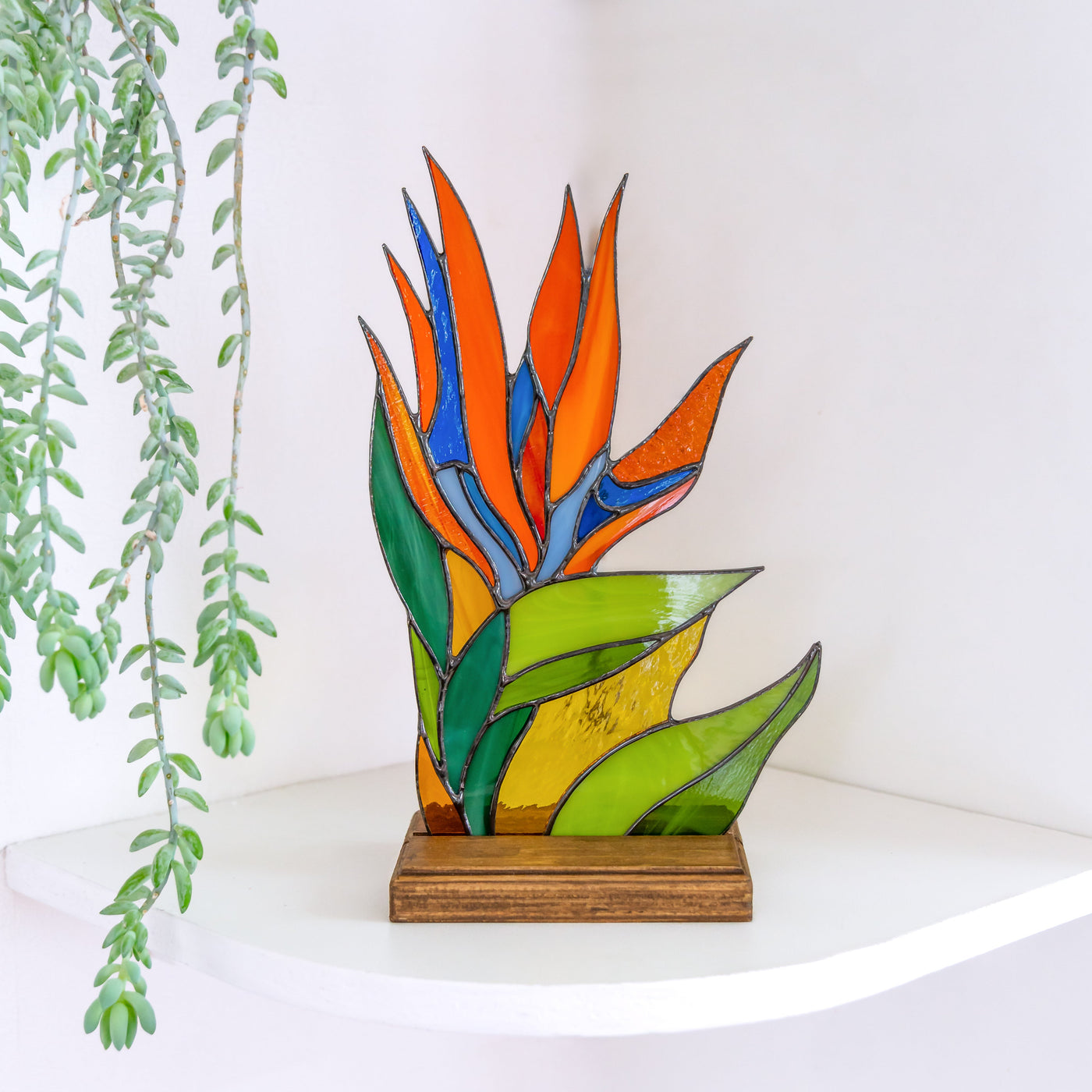 Stained glass strelitzia flower panel in a wooden base for table decor