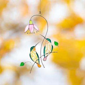 Two stained-glass birds perched on a branch