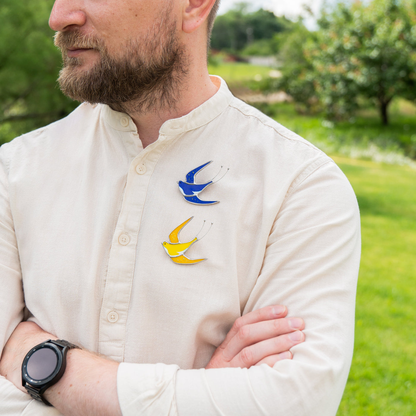 Blue and yellow swallow bird brooches on a man shirt