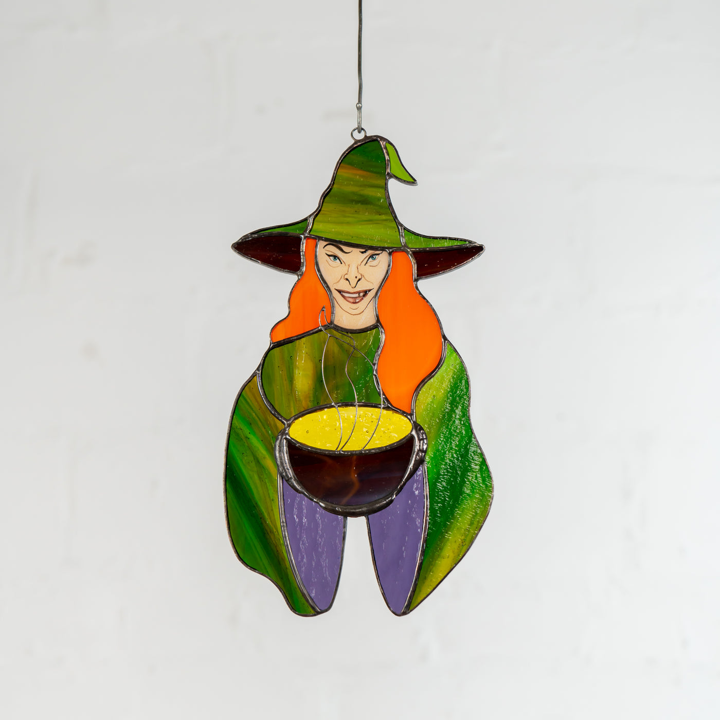 Stained glass red-haired witch with the pot suncatcher for Halloween