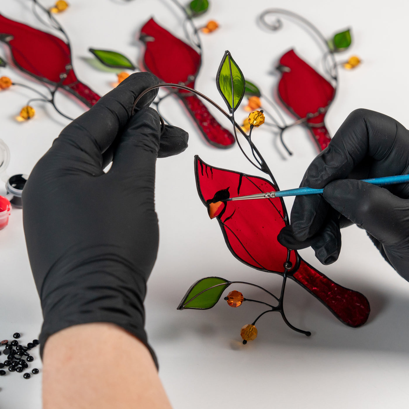 the handcrafting process of the cardinal bird suncatcher made of stained glass