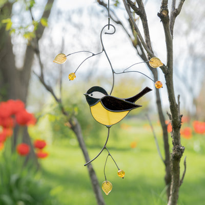 Stained glass black chickadee on the branch of stained glass for window