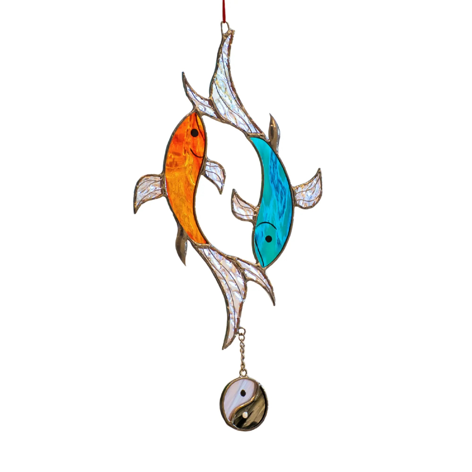 Stained glass suncatcher with two fish and a yin-yang symbol on a white background