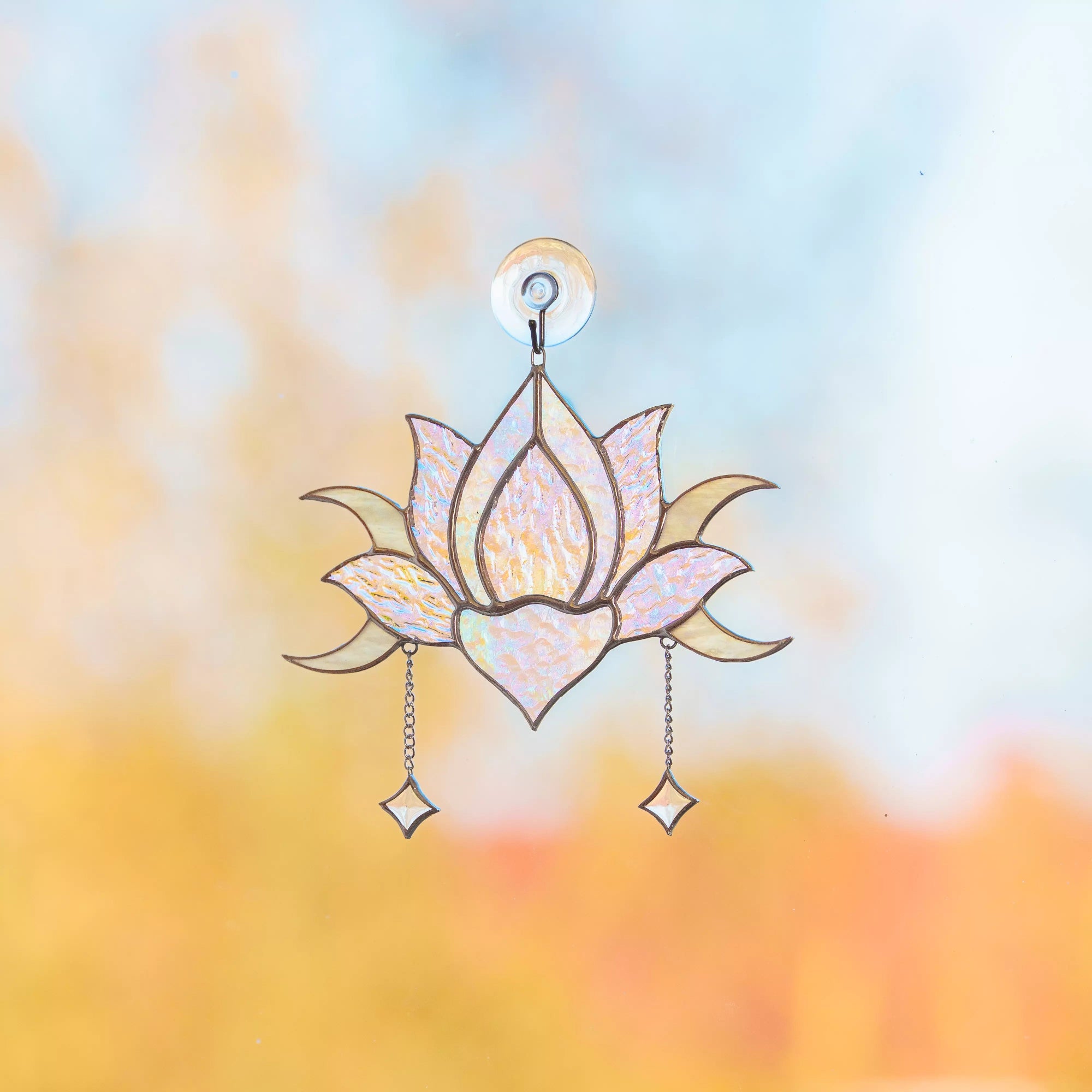 Stained glass lotus flower window hanging ornament with a blurred background