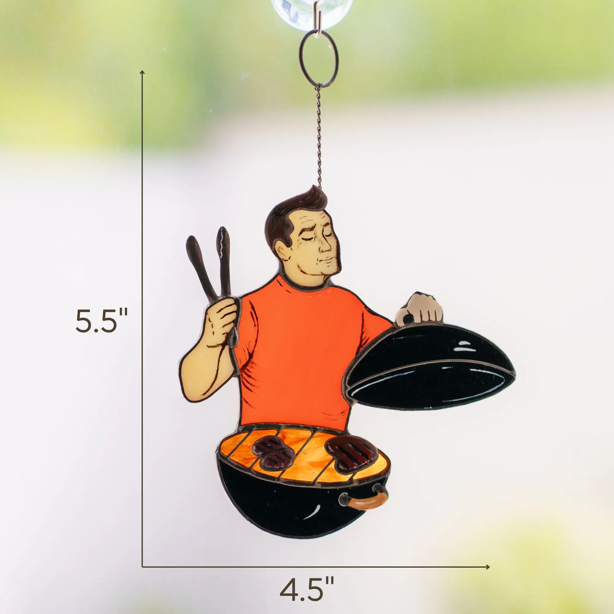 Stained glass ornament of a man grilling with measurements on a white background