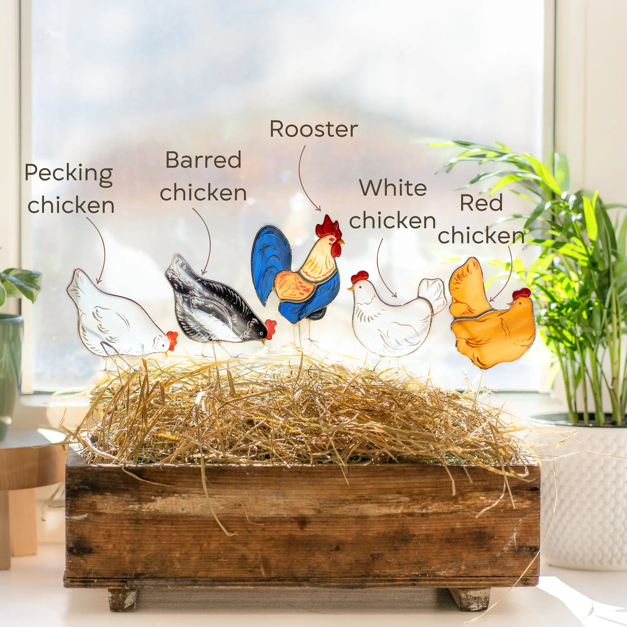 Variation of four stained glass chickens and rooster plant stakes in a room setting