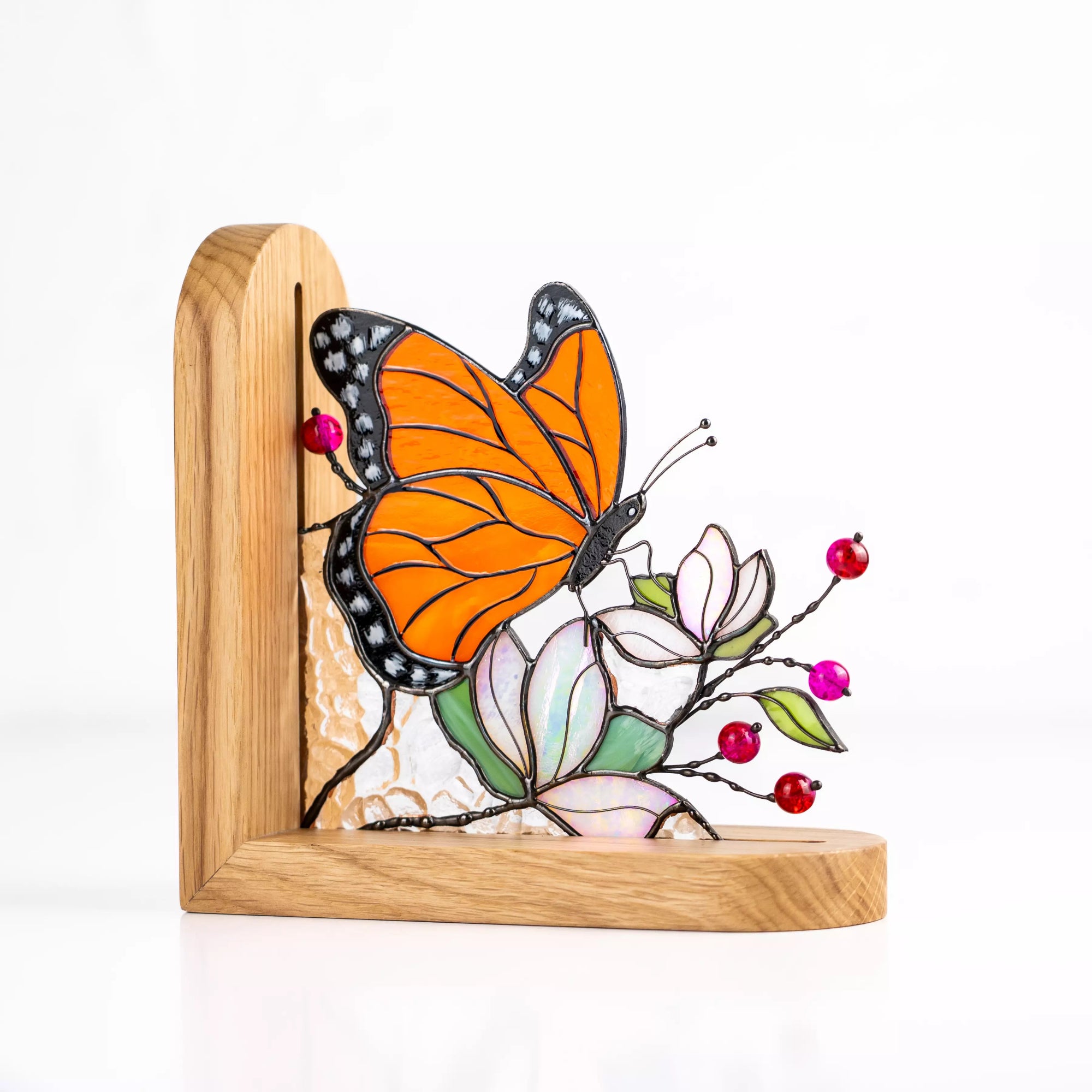 Decorative stained glass butterfly bookend holding books upright on a wooden shelf.
