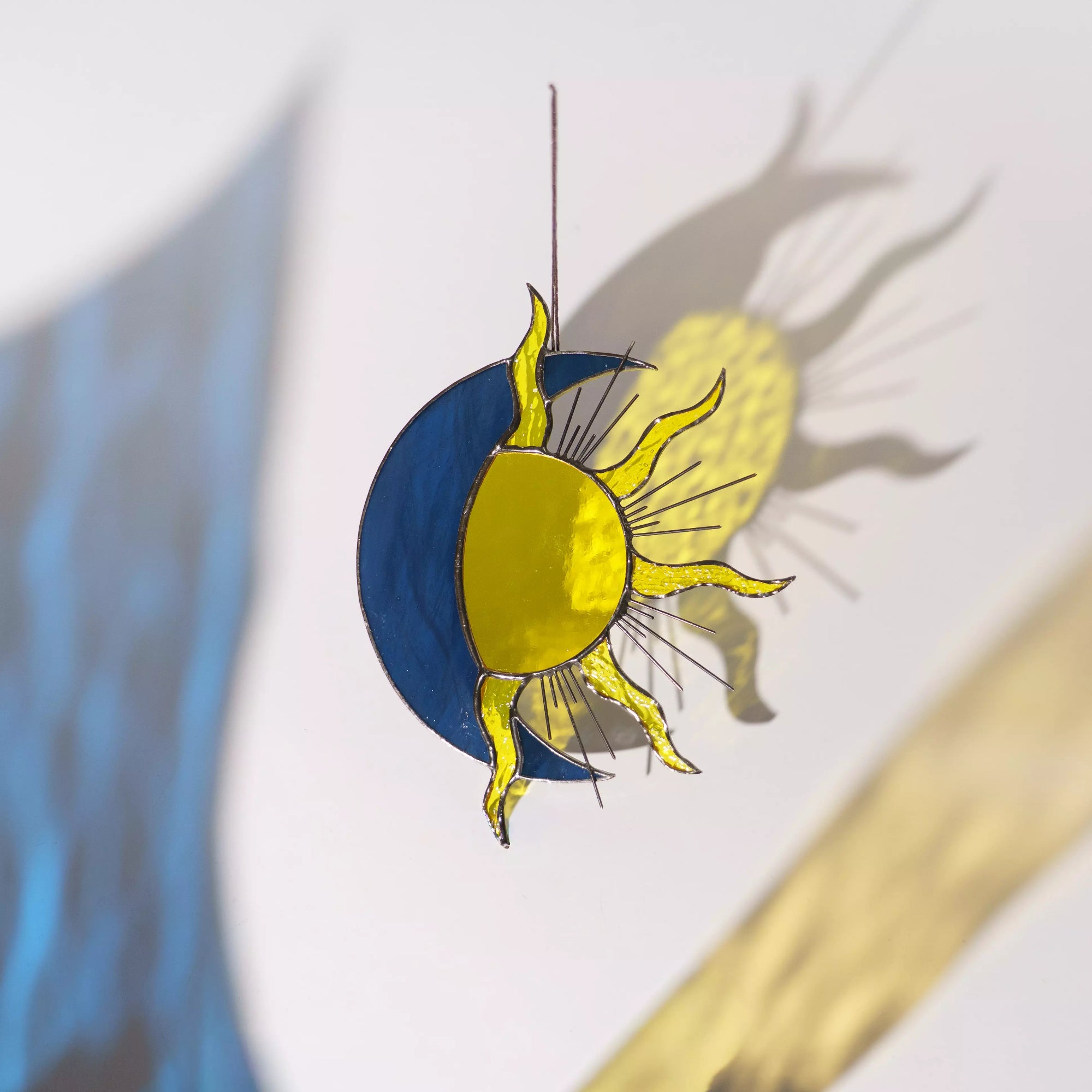 Stained glass sun and moon design on a white background