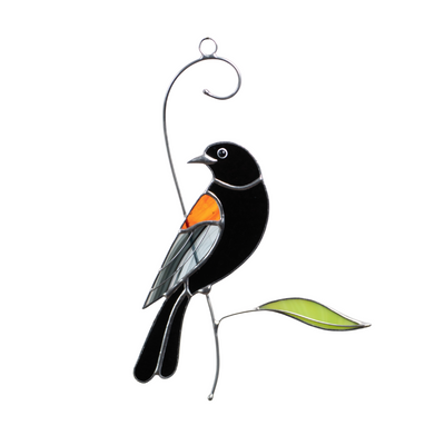 Stained glass blackbird hanging with orange wing, perched above a green leaf, ideal for garden lovers.