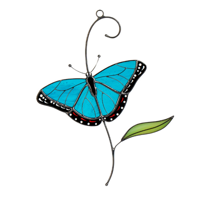 Stained glass morpho butterfly with deep blue wings and a green leaf accent.
