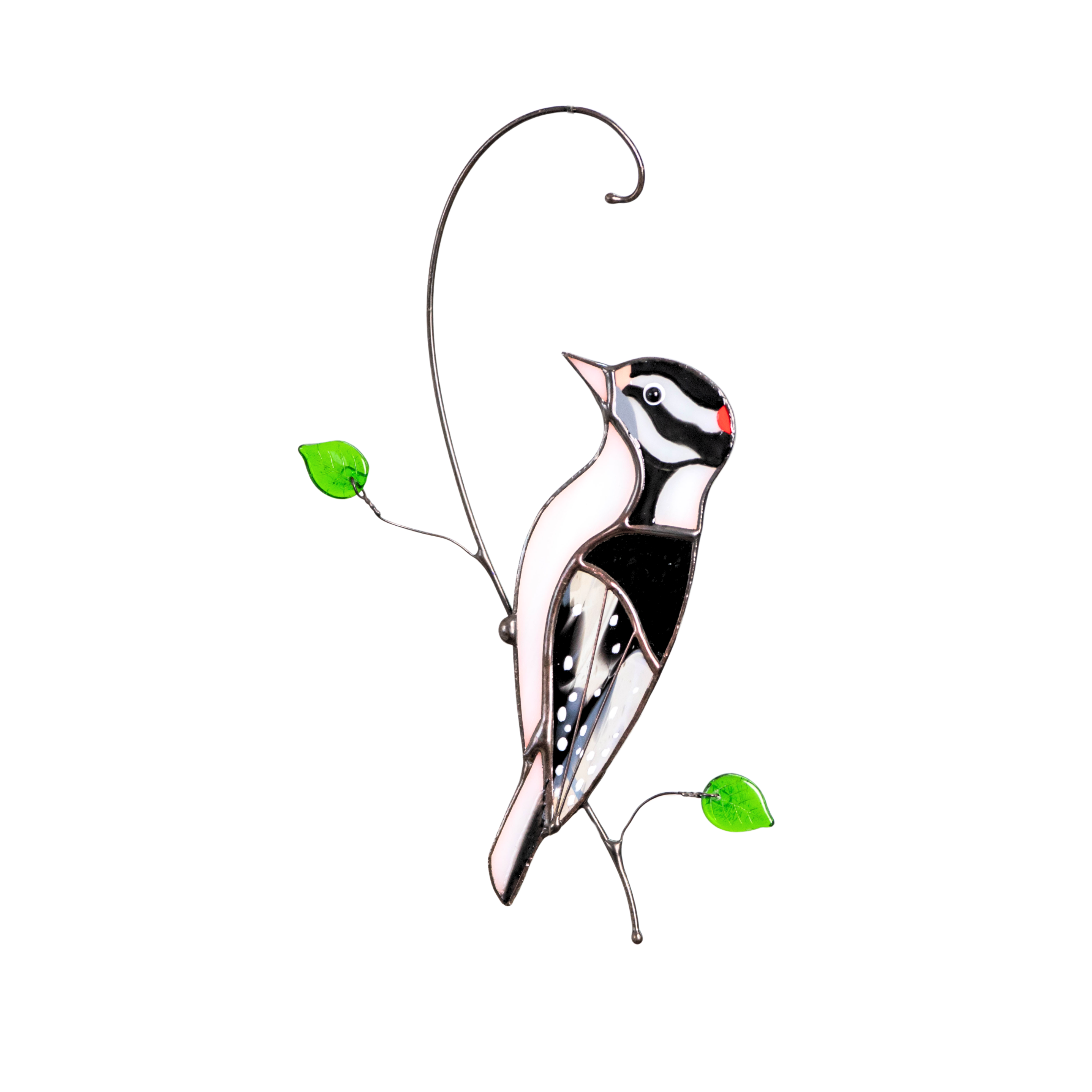 Detailed stained glass woodpecker in black and white with a red crest and green glass leaves