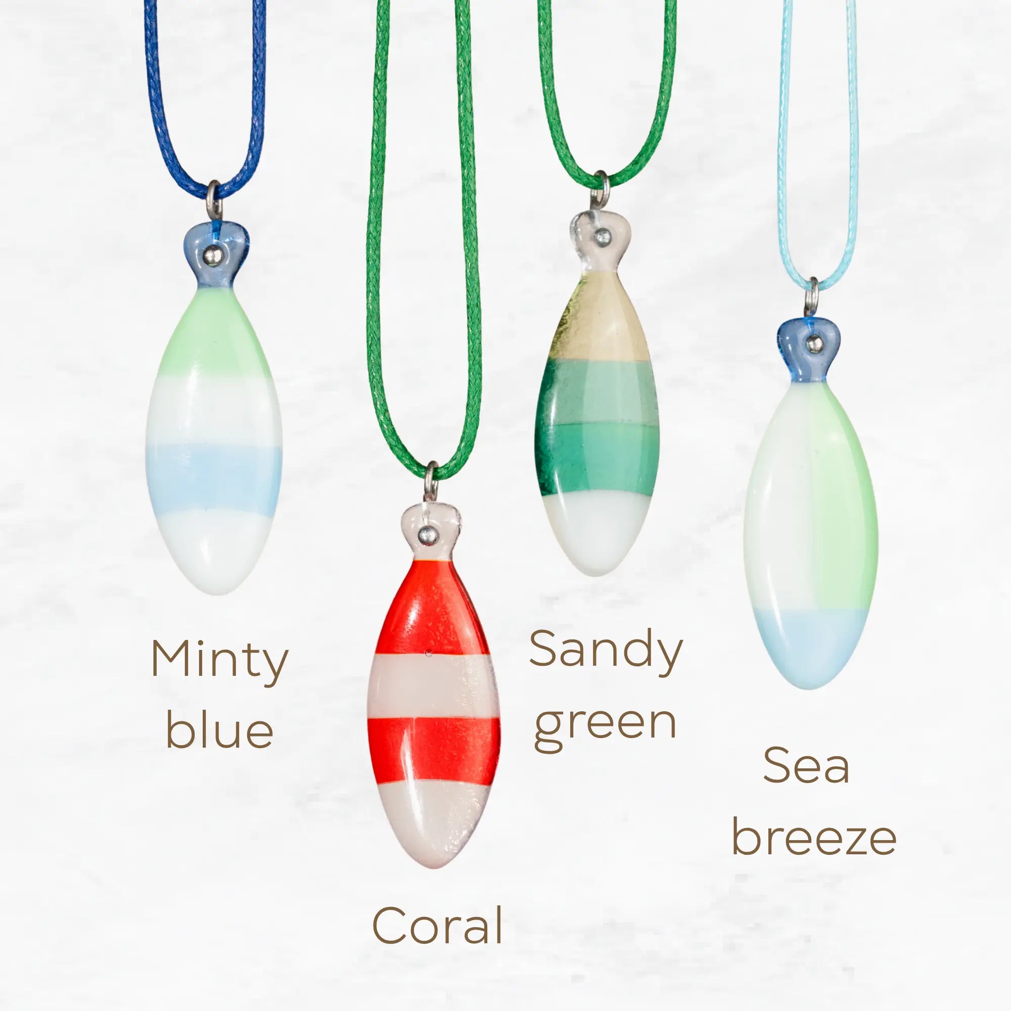 Four stained glass fish necklaces in different color combinations with names: Minty Blue, Coral, Sandy Green, and Sea Breeze.

