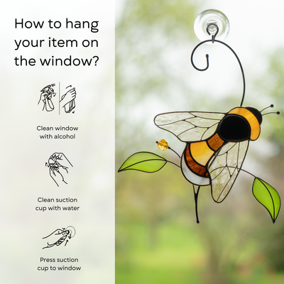 Bumble bee stained glass hanging on a window with green leaves and a yellow bead with instruction beside: clean window and suction cup, press a cup to the surface.