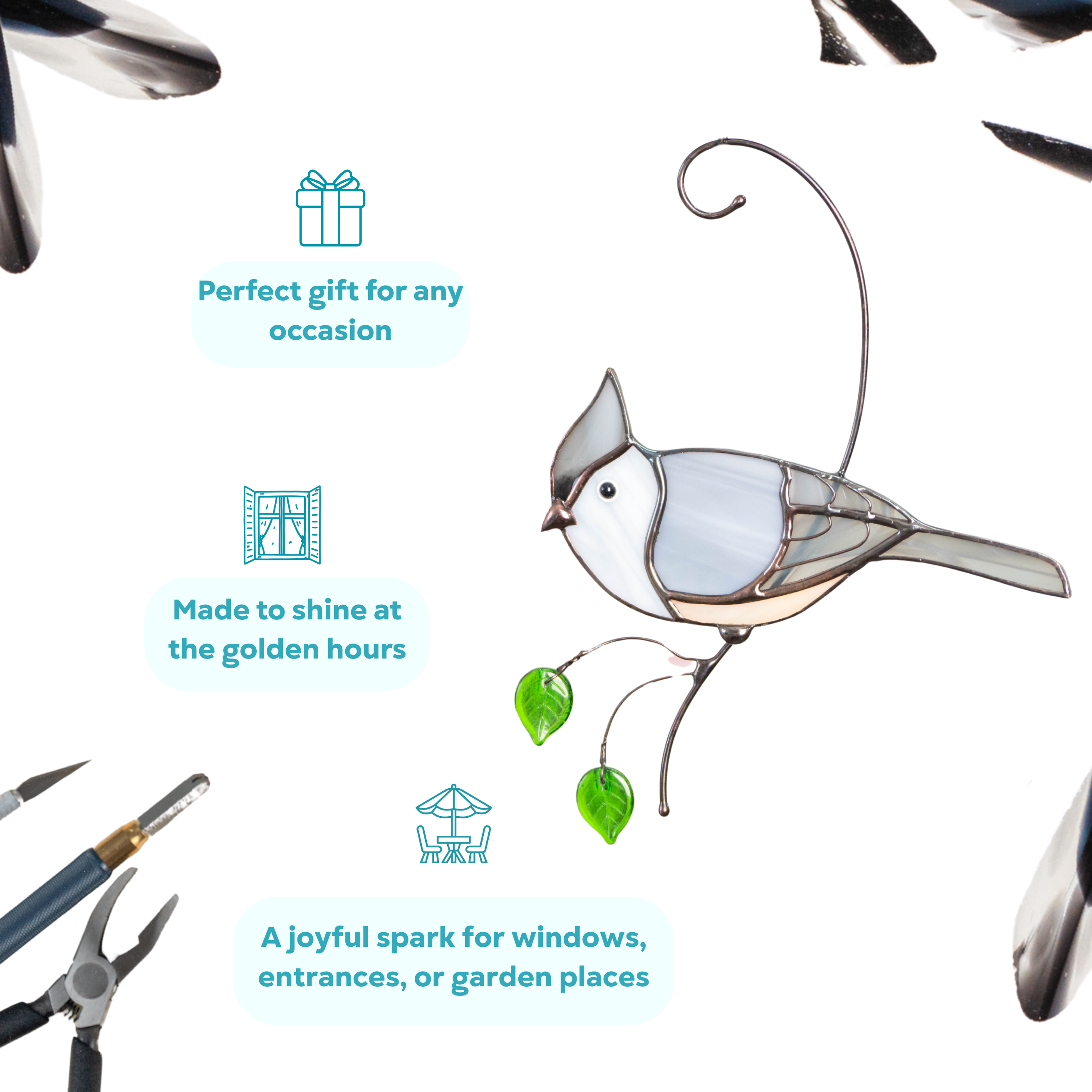 A stained glass tufted titmouse in gray tones with green glass leaf hanging from a curved branch.